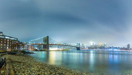 Fototapeta premium Dumbo between the Manhattan and Brooklyn Bridges in NYC at night, panorama and long exposition,