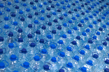 Lot of bottles worth with clean cool natural water. Group of plastic bottles with water stand in a row.