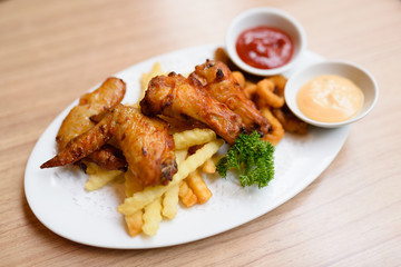 A plate of fried food  is on the wooden table.