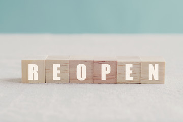Wooden blocks with REOPEN word, business reopening plan post covid-19 coronavirus pandemic concept
