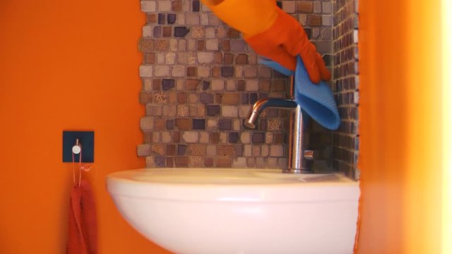 Nettoyage par d&eacute;sinfection du coronavirus en pulv&eacute;risant un antisepsie assainissent dans une salle de bain, muni de gant de protection.