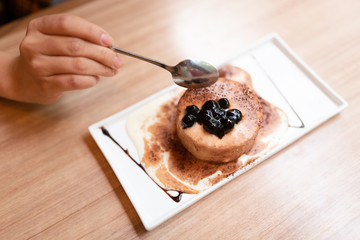 Woman having sweet food on the wooden table.
