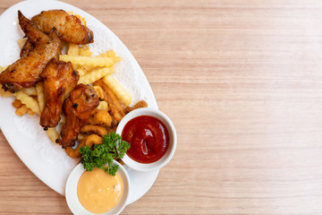 A plate of fried food is on the wooden table.