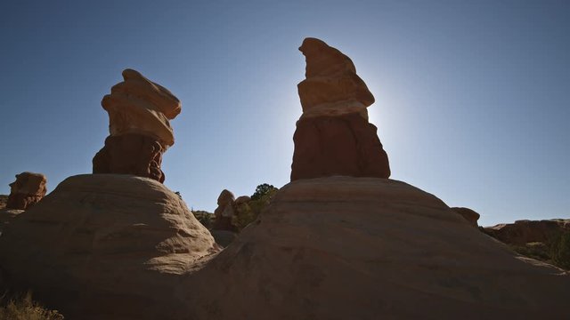 Panning view of the sun behind desert hoodoos in Escalante National Monument.