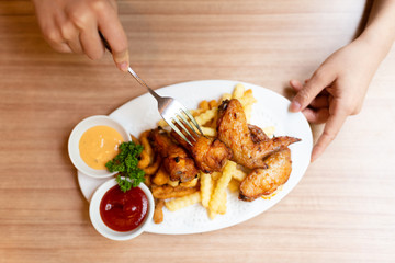 Woman having fried food on the wooden table.