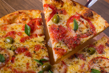 Pizza Marguerita slice being served with a metal spatula. Traditional Neapolitan Pizza, typical...
