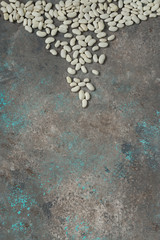 White beans on a gray background. Healthy food for vegans. Vertical position. Top view. Copy space
