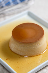 Dessert milk pudding with caramel sauce. Served on a white plate. Brazilian sweet