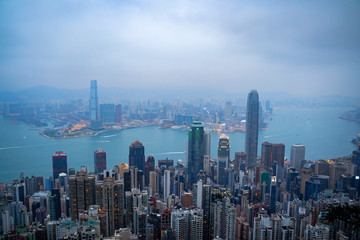 Aerial view of Hong Kong city skyline during misty and hazy sunset.
