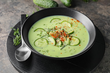 Bowl with cold cucumber soup on table