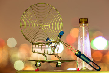A blurry abstract background of bokeh lights falling against a small chicken frying basket placed on a wooden floor.