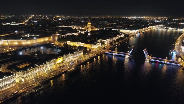 Aerial above night dark cityscape St. Petersburg historic city center. Neva River reflection of backlight. Drawbridge bridge divorced. Road traffic. Saint Isaac's Cathedral, Admiralty, Winter palace