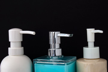 Fototapeta na wymiar Close up top view of colorful soap dispenser for bathrooms or kitchen sinks on a black background