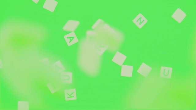 Random Alphabet Scrabbles falling down to green background . alphabet dropping on green table