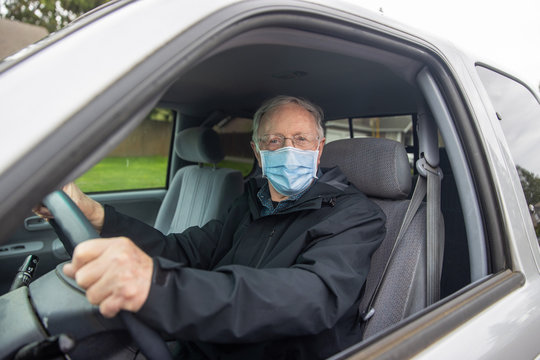 Senior Citizen Mature Man Driving While Wearing Medical Mask To Prevent Covid-19 Coronavirus Infection