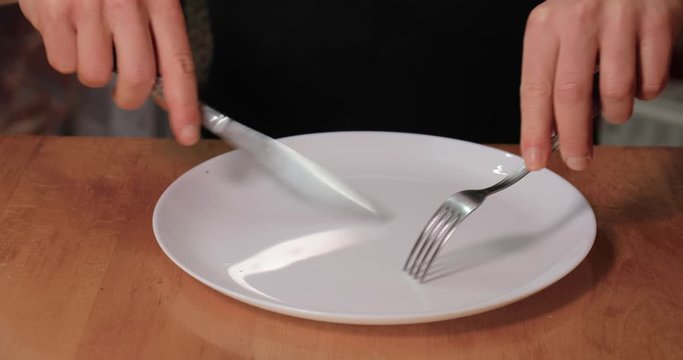 Fork and knife scratching plate makind a disturbing screeching sound