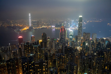 Obraz premium Lugard Road, Hoang Kong - January 1, 2020: Aerial view of night scene at Hong Kong city skyline during misty and hazy sky.
