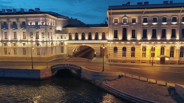 River canal St. Petersburg Neva. Historic building Hermitage theater famous arch and small bridge. Winter groove river cruises landmark. Night illumination reflection. Deserted street. Aerial approach