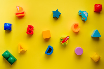 Top view on children s toys on a yellow background. Children's toys on the table. concept for...