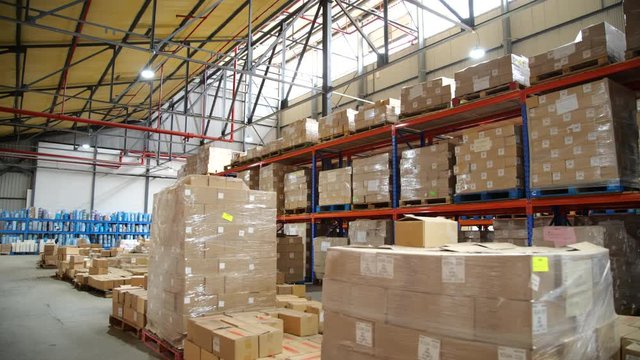 Inside of large full warehouse, pallets of cardboard boxes ready for shipment, supply chain management concept