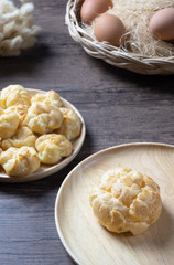 Delicious eclairs or cream puff or French profiteroles or choux dough filled with vanilla custard cream,on wooden background.