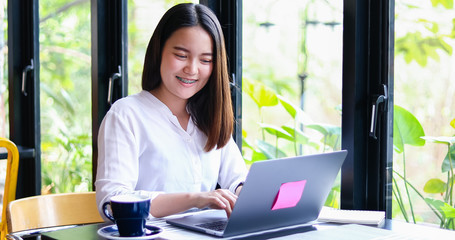 Beautiful Asian business women checking document and using notebook working from home for social distance and self responsibility concept