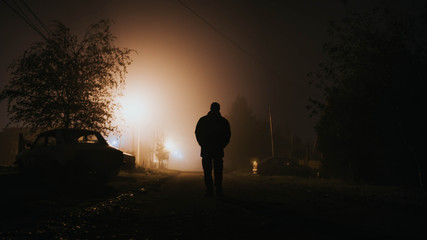 silhouette of a man walking on the road