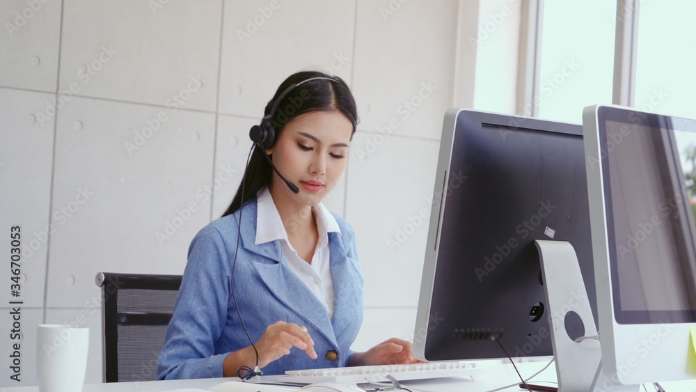 Poster customer support agent or call center with headset works on desktop computer while supporting the cu