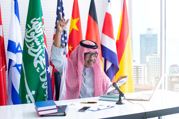 Arab businessmen are excited about the information in the document, national flags on poles on background, Arabic letters mean ”There is no god but Allah and Muhammad is the messenger of Allah"