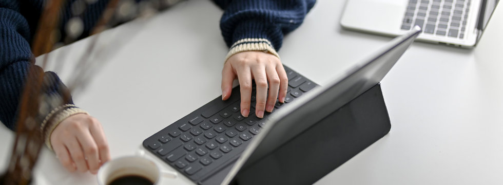 Cropped shot of female photographer working on her project with tablet,  smartphone and camera