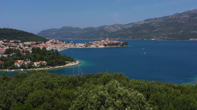 Historic Mediterranean Town of Korcula in Croatia - Aerial revealing shot with sailboats navigating