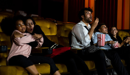 Shocked audience watching a horror movie in the cinema