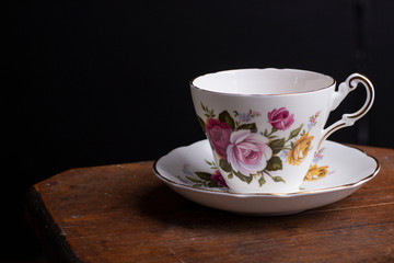 A vintage teacup sitting on an old wooden table 