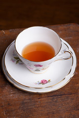 A vintage teacup sitting on an old wooden table 