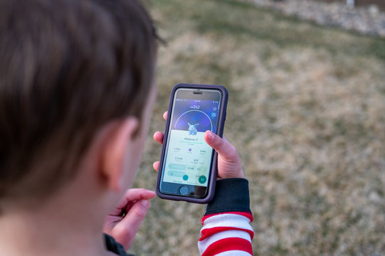 Tiffin, Iowa, USA: 4/2020:  Caucasian boy playing Pokémon Go, a popular mobile app game. 