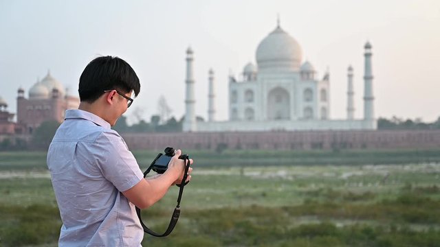 Young man enjoy a beautiful Taj mahal photographing view in evening