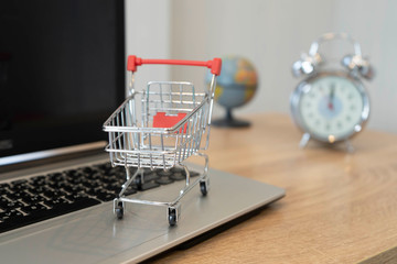 Online shopping concept. Shopping cart, on laptop