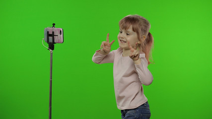 Girl child makes selfie vlog, blogging, video call on mobile phone using monopod