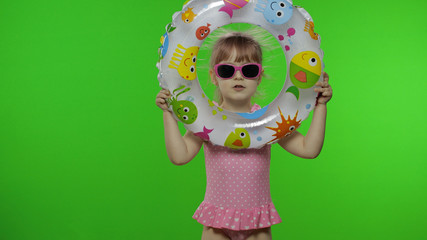 Funny child girl play, looking out of the swimming ring. Vacation on sea concept
