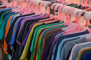 Huge selection of different used clothes for men, women and children on the rack in a second hand...