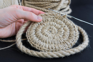 girl knits jute eco-friendly basket for the interior, top view. learning to knit online