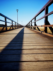 Empty new wooden bridge with fence shadow