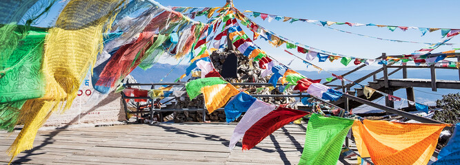 Prayer flags and stupa at the peak of Shika Snow Mountain or Blue Moon Valley, landmark and popular for tourists attractions in Zhongdian city (Shangri-La). Yunnan, China. Asia travel concept