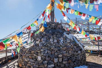 Prayer flags and stupa at the peak of Shika Snow Mountain or Blue Moon Valley, landmark and popular for tourists attractions in Zhongdian city (Shangri-La). Yunnan, China. Asia travel concept