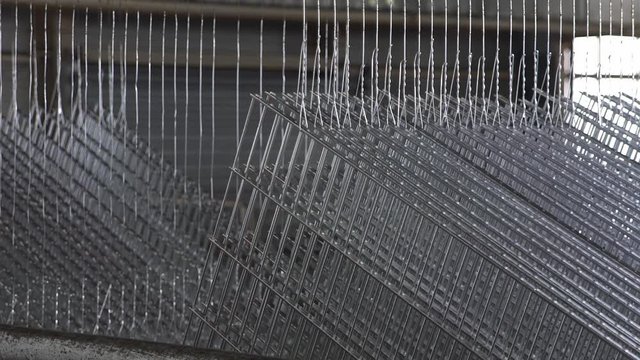Galvanized Metal Fence hanging during production process. Slowly extracted from the zinc bath.