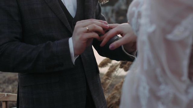 Young people wear each other rings at the ceremony. Hands close-up