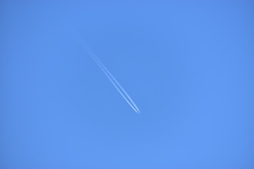 Image of Airplane leaving contrails in the clear sky