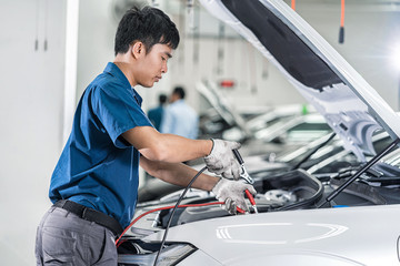Asian mechanic Checking and repairing the car in maintainance service center which is a part of...