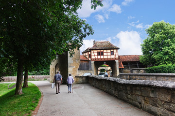 Two elderly people walking near the history wall in Rothenburg ob der tauber, Germany.