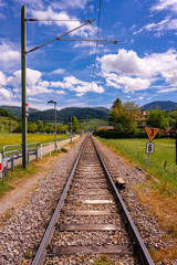 View along railway tracks with the view to the mountains in the Black Forest in beautiful weather